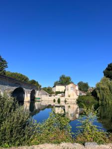 a bridge over a river with a reflection in the water at La Rive Chambre d hôtes The Riverside Retreat in Jarnac