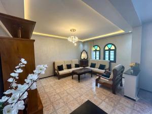 a living room with a couch and chairs and a table at Villa TAHA piscine jacuzzi clim in Martil