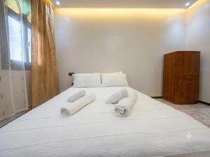 a large white bed with white towels on it at Villa TAHA piscine jacuzzi clim in Martil