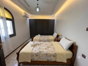 a bedroom with two beds and a window at Villa TAHA piscine jacuzzi clim in Martil