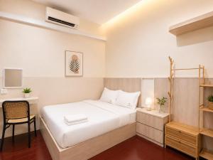 a bedroom with a white bed and a desk at Commune Lane Guesthouse, George Town in George Town
