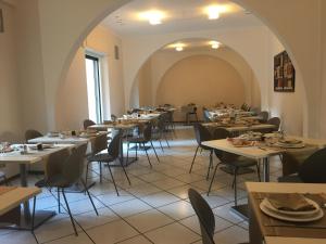 ein Speisesaal mit Tischen und Stühlen und einem Torbogen in der Unterkunft Hotel Al Capo in Varigotti