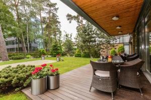 a patio with a table and chairs and flowers at Guest House Aštuoni in Palanga