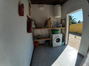 a small kitchen with a washing machine in a room at Le tournesol Belle villa in Maroantsetra Airport