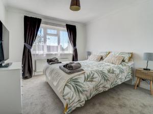a bedroom with a bed and a tv and a window at Dorset Escape in Gillingham
