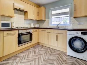a kitchen with a washing machine and a microwave at Dorset Escape in Gillingham