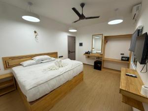 a bedroom with a bed with a ceiling fan at Piyo in Thoddoo