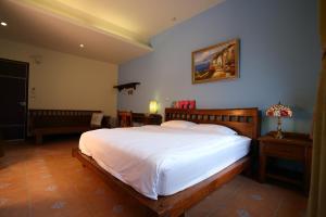 a bedroom with a large bed with white sheets at Qian B&B in Jiamin +5 photos
