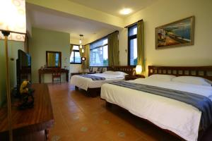 a hotel room with two beds and a television at Qian B&B in Jiamin