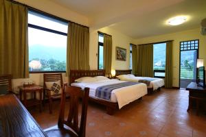 a hotel room with two beds and large windows at Qian B&B in Jiamin