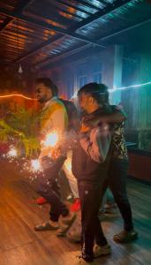 a group of men standing on a dance floor holding sparklers at Secret Escape Colonial Bungalow in Ooty
