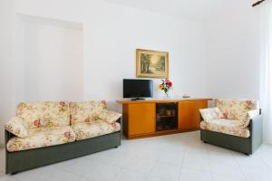 a living room with two couches and a tv at Casa al Belvedere in Vico Equense