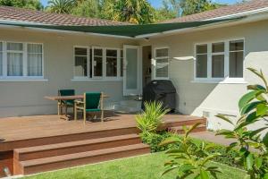 a wooden deck with a table and chairs on a house at Brougham Street B and B in Nelson