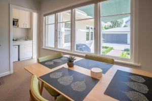 a dining room with a table and a large window at Brougham Street B and B in Nelson