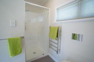 a bathroom with a shower with a green towel at Brougham Street B and B in Nelson +6 photos