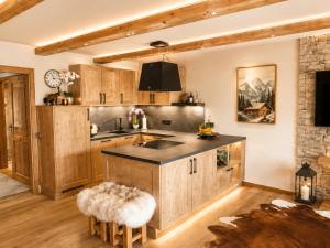 a kitchen with wooden cabinets and a counter top at Arber Resort & Wellness Šumava in Železná Ruda