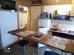 a kitchen with a wooden table and a counter top at De particulier à particulier in Mauléon-Barousse