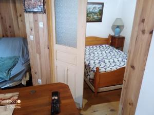 a small bedroom with a bed and a door at De particulier à particulier in Mauléon-Barousse