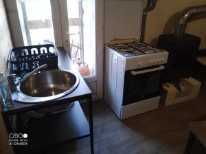 a kitchen with a stove and a sink and a stove at De particulier à particulier in Mauléon-Barousse