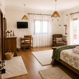 a bedroom with a bed and a table and a chair at Casa da Risca Amarela in Leiria +4 photos
