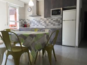 a kitchen with a table with chairs and a white refrigerator at Dúplex Isabel in Toledo