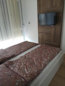 a bed in a room with a flat screen tv at AH Home Delux Centar in Sarajevo