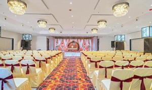 a large room with rows of tables and chairs at Hotel Skyland Khammam in Khammam