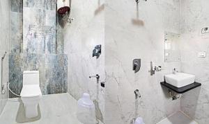 a bathroom with a white toilet and a sink at Hotel Skyland Khammam in Khammam +24 photos