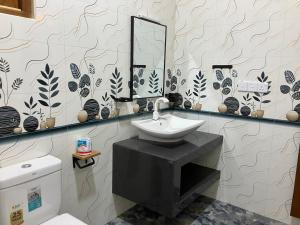 a bathroom with a sink and a mirror and a toilet at Aki Villa in Pasikuda +54 photos