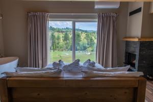 a bedroom with a large window with a view of a field at Ura e Kovacit Resort & Agrotourism in Voskopojë +181 photos