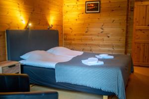 a bedroom with a bed with two towels on it at Nature Resort Tiveden in Tived
