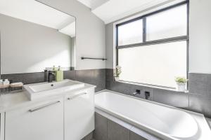 a white bathroom with a sink and a window at Your Beach Getaway in Singleton +17 photos