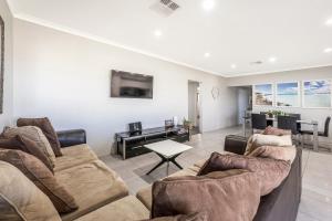 a living room with two couches and a dining room at Your Beach Getaway in Singleton