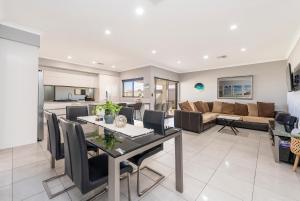 a dining room and living room with a table and chairs at Your Beach Getaway in Singleton