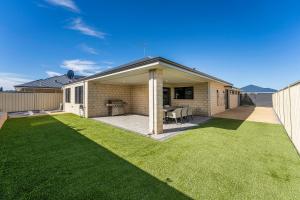 a house with a patio and a grass yard at Your Beach Getaway in Singleton