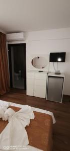 a bedroom with a bed and a sink and a mirror at Vila Elegance in Costinesti