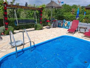 a blue swimming pool with chairs and an umbrella at Kuća za odmor Janković in Ludbreg +25 photos