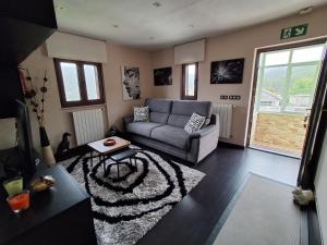 ein Wohnzimmer mit Sofa und Teppich in der Unterkunft Casa Pasarón in Luarca