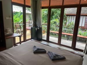 a bedroom with a bed with two black slippers on it at Slow Life Sabaidee Pai in Pai +119 photos