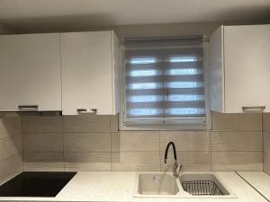 a kitchen with a sink and a window at Villa Kazani by Karda Suites in Chios