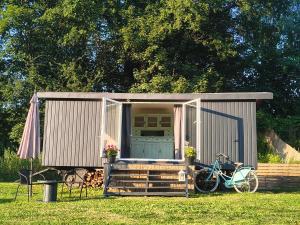 a small shed with a bike parked in the grass at Tiny House Zagroda Kopytkowo in Ropica Górna