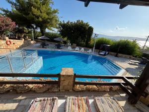 a large swimming pool with chairs in front of a house at Villas Vista Del Mar in Kissamos
