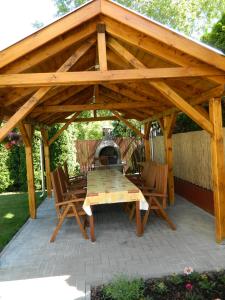 un pabellón de madera con una mesa y sillas en un patio en Csernai Villa, en Balatonfüred