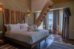 a bedroom with a large bed with a wooden headboard at Ura e Kovacit Resort & Agrotourism in Voskopojë