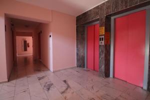 a hallway with red doors and a tile floor at Golden Moon Apart Hotel in Kuşadası +16 photos