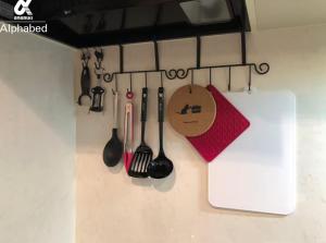 a kitchen counter with spoons and utensils on a wall at Alphabed松山城西 in Matsuyama +26 photos