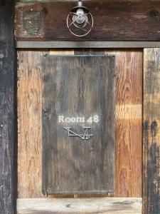 eine Holztür mit der Aufschrift „Zimmer“ in der Unterkunft Room 48 in Takayama