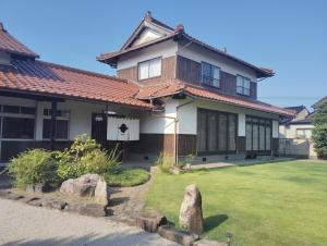 a house with a grass yard in front of it at MEKIKI出雲 izumo in Izumo