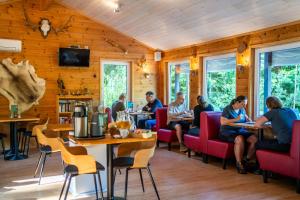 a group of people sitting at tables in a restaurant at Nature Resort Tiveden in Tived