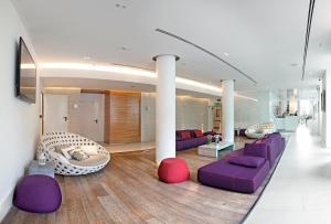 uma sala de estar com mobiliário roxo e branco em Europa Hotel Design Spa 1877 em Rapallo